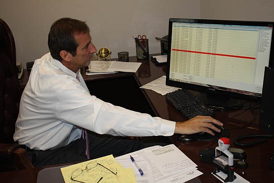Photo by Joe Wilhelm Jr. - Steve Johnroe, director of court operations for the Civil Court for the Clerk of the Circuit and County Courts, looks up civil filings being processed by the court. The Supreme Court of Florida required that probate, family,...