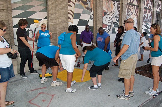 The 263 yellow paw prints are painted each year on the sidewalk, including along Ocean Street at the Bostwick Building.