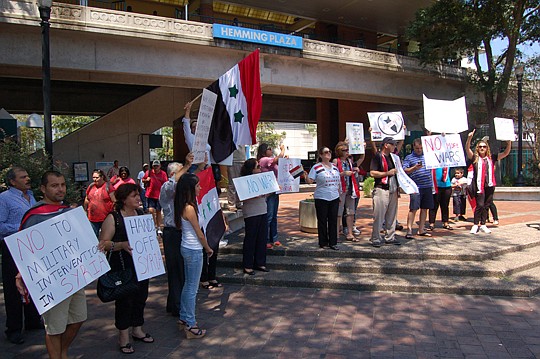 About 50 people protested Thursday in Hemming Plaza against the potential U.S. military action in Syria. "We don't want to see what happened in Afghanistan and Iraq happen in Syria," Mary Zeidan said.