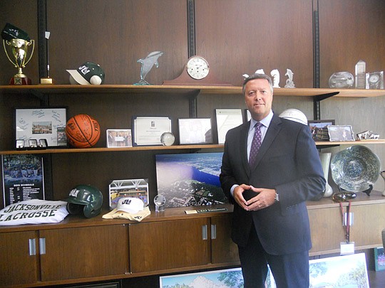 Photo by Tracy Jones - Jacksonville University President Tim Cost tries to represent the many components of the college on his office shelves, including pieces from many of the sports teams.
