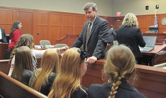 Jacksonville attorney Kelly Mathis talks with his wife and four daughters Wednesday before closing arguments in his trial in Sanford.