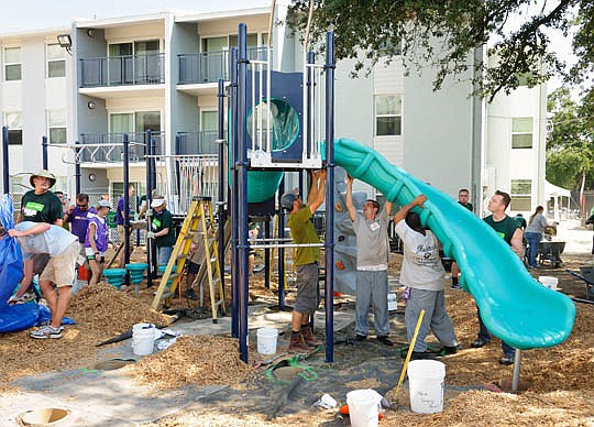Several agencies worked together Saturday to build a special playground in the Oakland Terrace neighborhood. Ability Housing of Northeast Florida Inc., Humana Inc., KaBoom and volunteers, including those above attaching the slide, worked for several h...