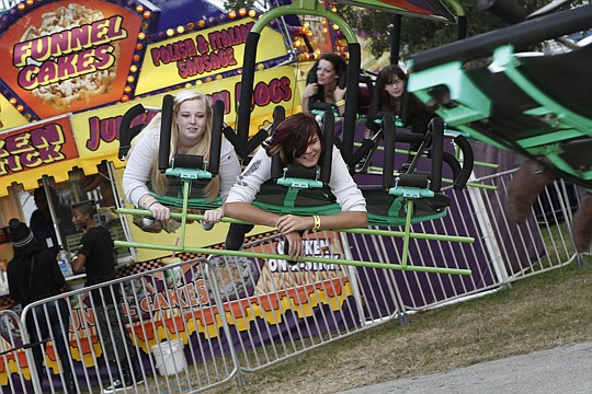 Leslee Pattford (left) and Payten Lucas get whipped around on the Cliffhanger ride Saturday at the Greater Jacksonville Agricultural Fair. This annual fair ended its run Sunday.