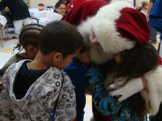 Children from the Sulzbacher Center greeted Santa Claus last year with a hug. Santa returns to the center today to surprise this year's residents.