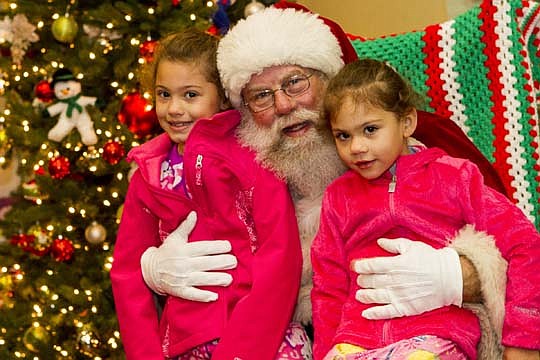 Families at the Sulzbacher Center were treated to a Christmas morning breakfast, then a visit from Santa Claus. Each of the 340 residents received a stocking and the 60 children at the center were given a gift. Above, sisters Lillian Spencer, 7, and D...