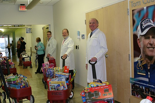 North Florida OB GYN and Brown Fertility collected more than 1,000 toys as part of a contest among departments in December. From left, Dr. Paul Rebenack; Dr. C. Cameron Greene, president of North Florida OB GYN; and Dr. T. Michael Phelan prepare to de...