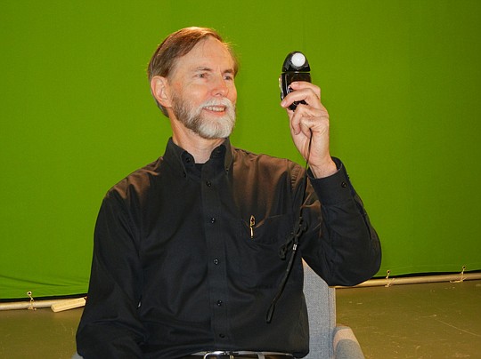 Photo by Karen Brune Mathis - Ray Hays uses a light meter to set the lighting for an interview at his Park Street offices.