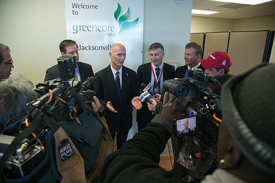 Gov. Rick Scott answers questions from the media during his stop at Greencore USA in Jacksonville Thursday. The governor also visited Metro Diner while in town.