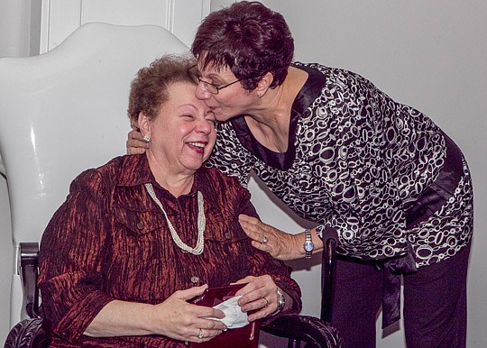 Rose D'Amour, left, is congratulated by her sister, Joanne Herro, after the Young Lawyers Section of The Jacksonville Bar Association named its volunteer award after D'Amour. She is the judicial assistant for Chief Judge Mark Mahon. Herro is visiting ...