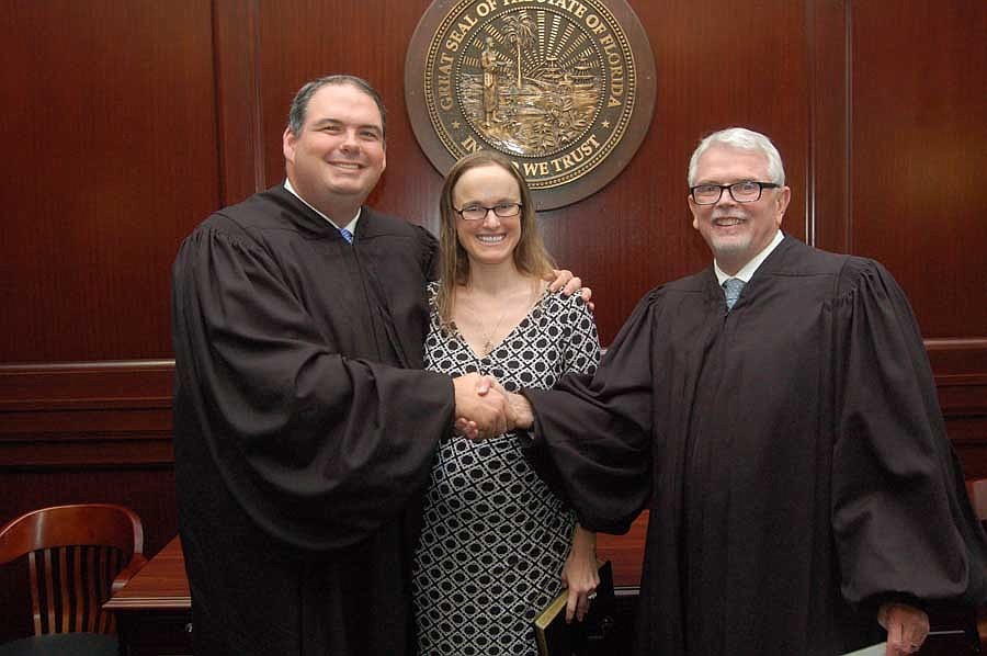 Circuit Judge Eric Roberson, left, with his wife, Helen, was welcomed to the 4th Judicial Circuit bench by Chief Judge Mark Mahon when he was sworn in June 19.
