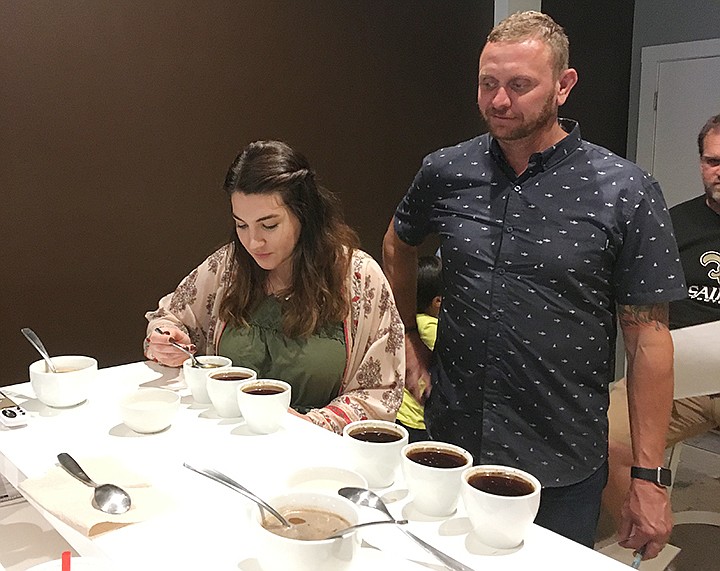 Social Grounds employee Katie Moberly and owner Jason Kelloway conduct a tasting exercise, called cupping, to test the coffeeâ€™s acidity and intensity.