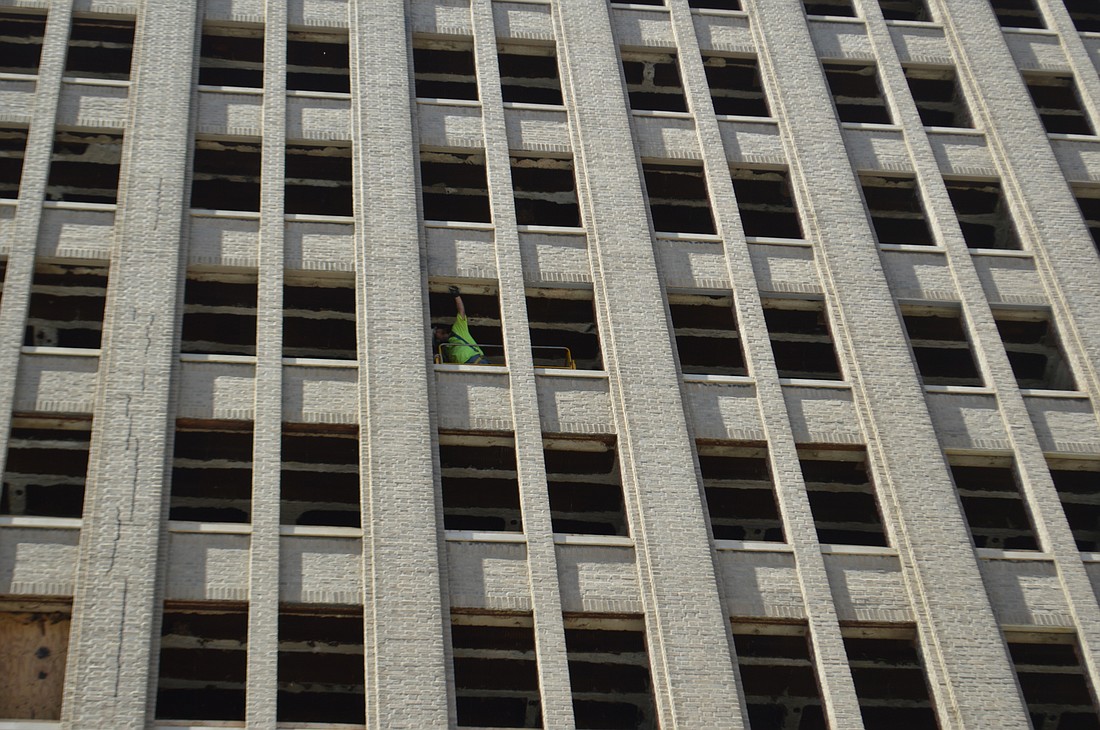 A window at the Barnett National Bank Building is worked on Wednesday.