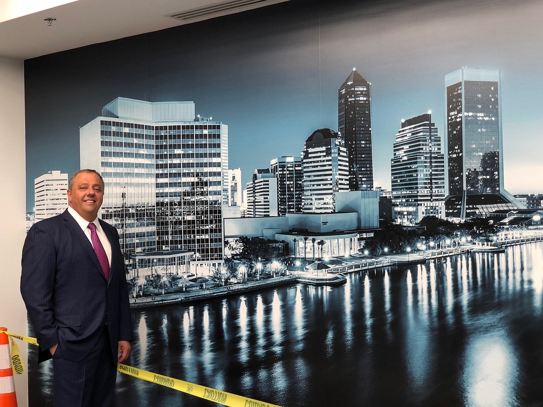 Jack Hanania, CEO and founder of Hanania Automotive Group, shows off the wall-length display of the Jacksonville skyline inside the new Audi dealership. Audi authorizes the dealership graphics and kept the skyline generic.