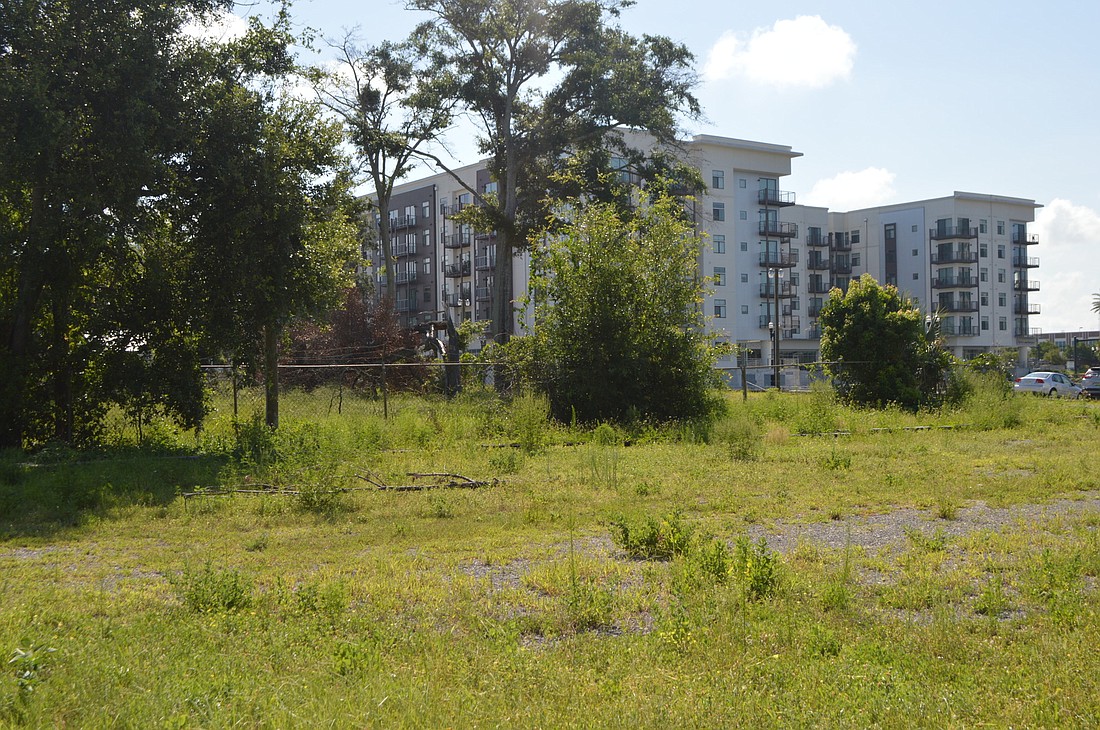 Weeds fill a vacant lot near 220 Riverside, the six-story, 294-unit apartment and retail complex along Riverside Avenue that helped launch growth and interest in the area.