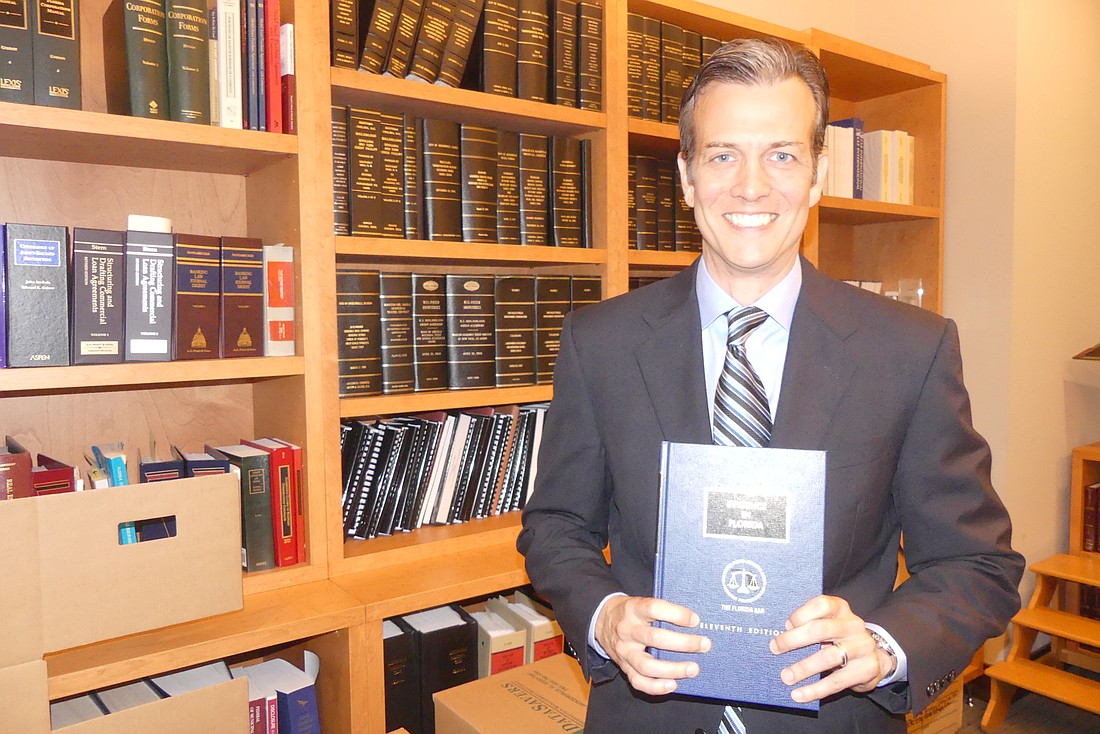 Michael Cavendish shows one of his two copies of the 11th edition of â€œEvidence in Floridaâ€ he helped write.