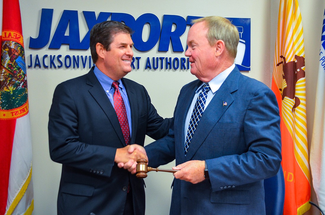 Jacksonville Port Authority immediate past board Chairman Ed Fleming, right, passes the gavel to his successor, John Falconetti.