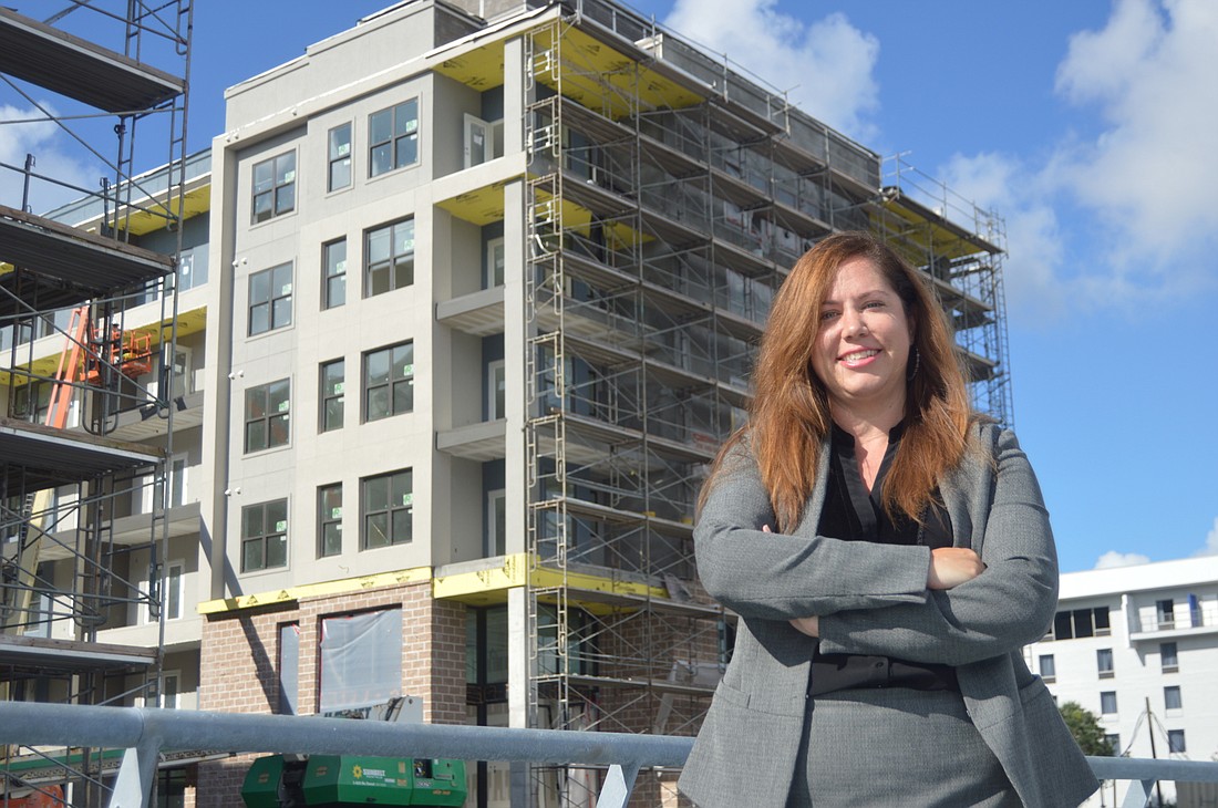 Morgan Williams, associate director of multifamily investment services at Colliers International, stands in front of the Broadstone River House Apartments on the Downtown Southbank.