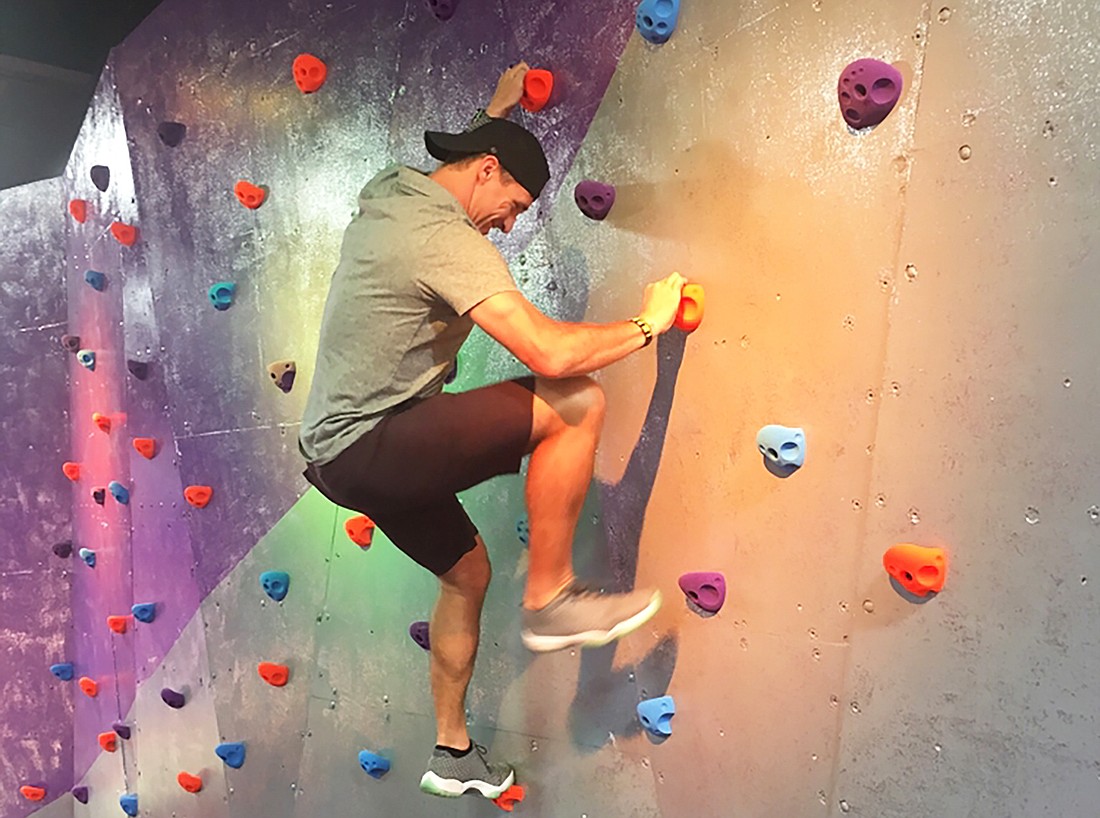 Saints quarterback Drew Brees, the owner of Surge Adventure Park, tries out the climbing wall.