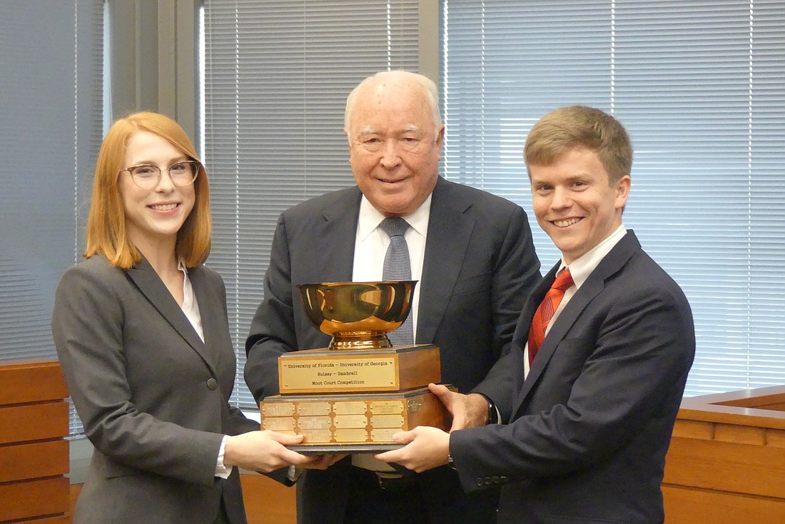 Smith Hulsey & Busey partner Steve Busey presented the Georgia-Florida Hulsey/Gambrell Moot Court Competition trophy to Jennifer Cotton and Miles Skedsvold, the team from the University of Georgia.