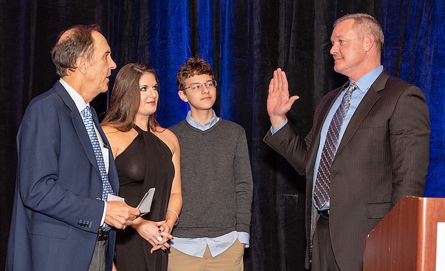 Sean Junker, right, sworn in as the 2019 president of the Northeast Florida Builders Association. His boss, Providence Homes CEO Bill Cellar, left, swore him in, while Junkerâ€™s wife, Amber, and son look on.