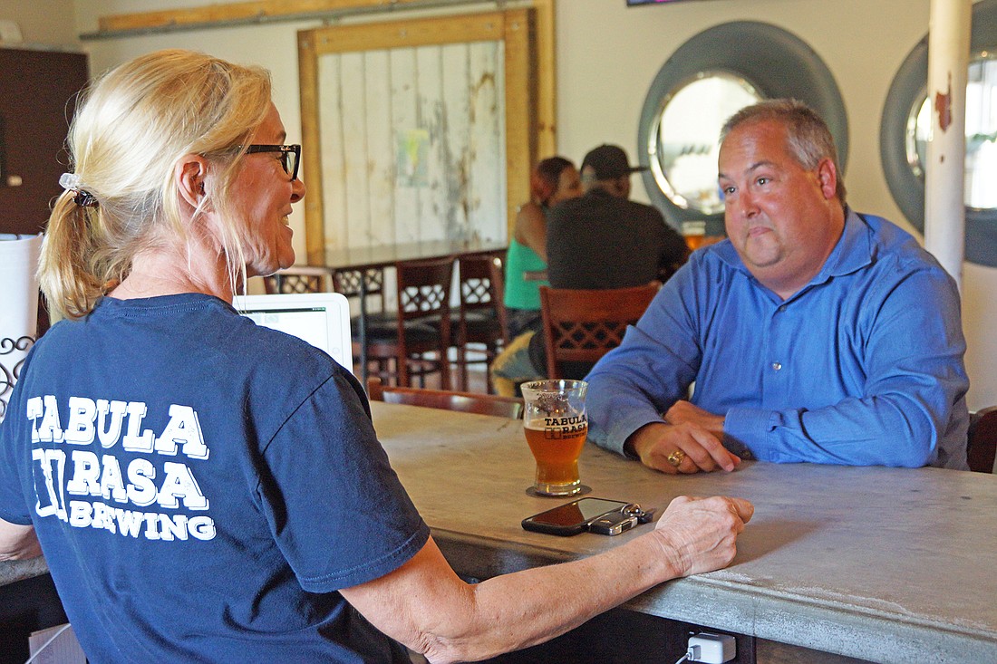Left, Tabula Rasa Brewing co-owner Jackie Peterson serves a customer at the brewery, which opened last year at 2385 Corbett St. in the Rail Yard District near Downtown.