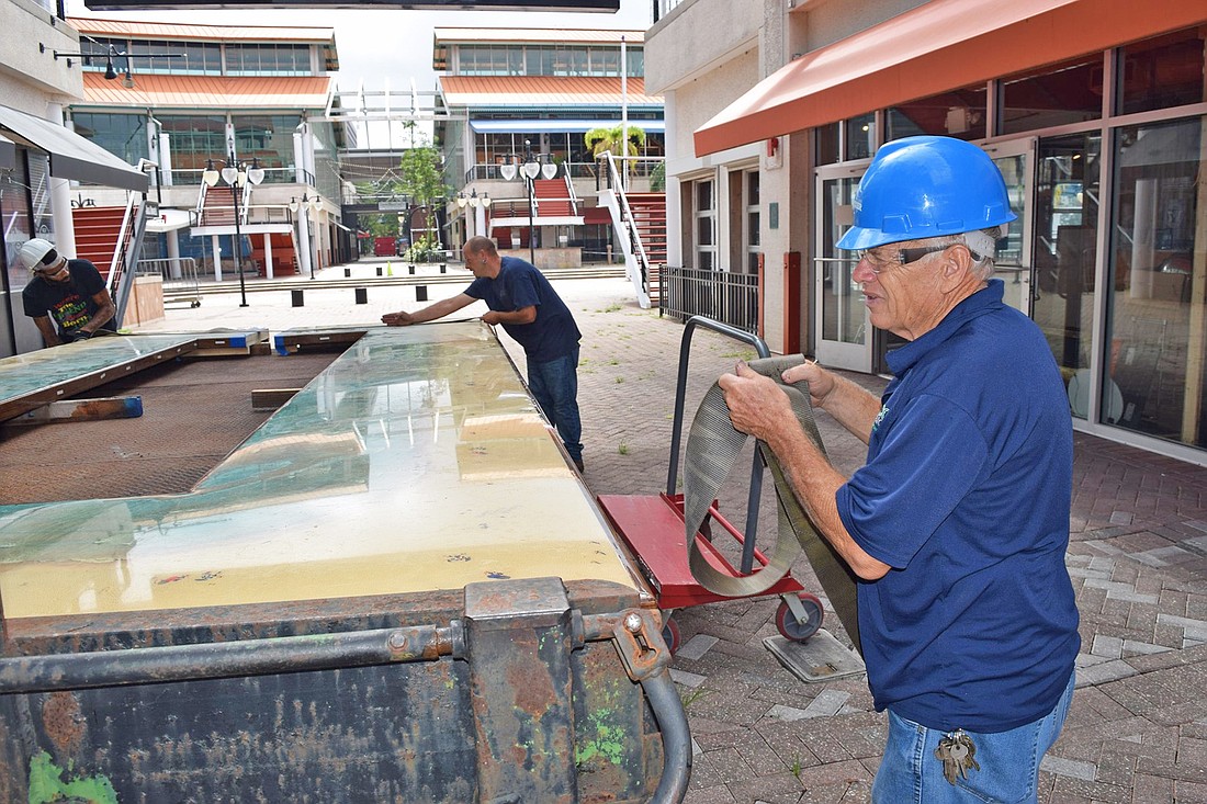 Workers from Eco Relics remove  bar top from  Hooters at The Jacksonville Landing. (Provided by Eco Relics)