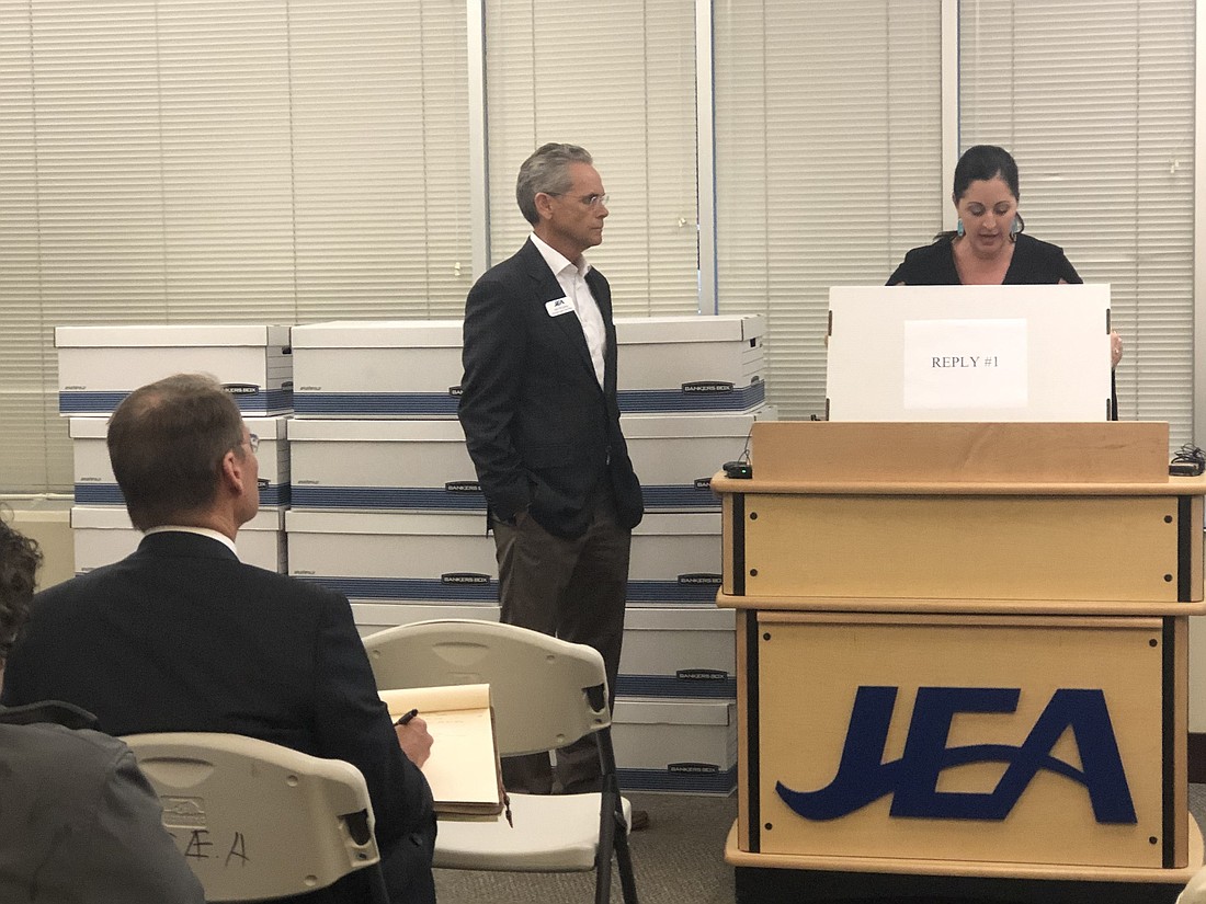 JEA Vice President and Chief Supply Chain Officer John McCarthy and JEA Chief Procurement Officer Jenny McCollum open and number the bids Monday at JEA headquarters.