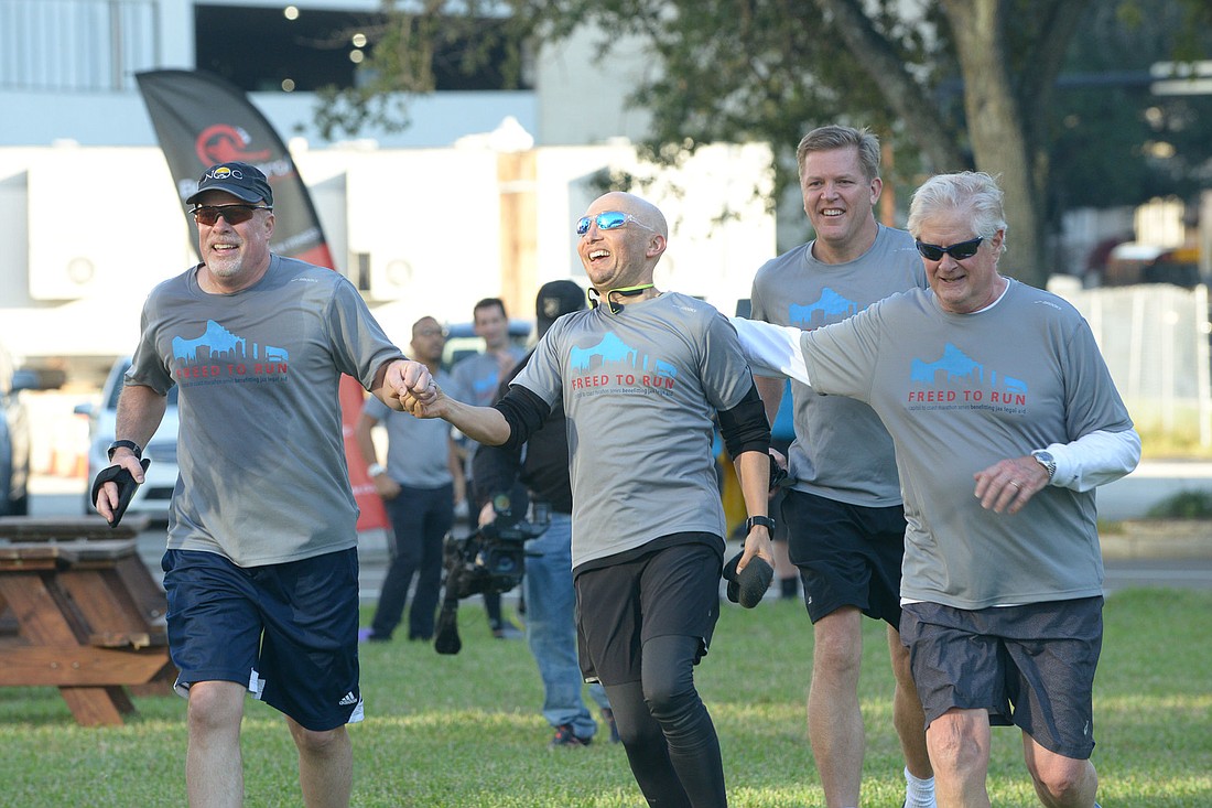 From left, Jacksonville Area Legal Aid CEO Jim Kowalski, Gunster attorney Mike Freed, Circuit Judge Steven Fahlgren and Circuit Judge Hugh Carithers cross the 2018 Freed to Run finish line at the Duval County Courthouse.