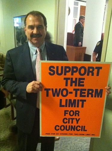 City Council member John Crescimbeni holds his 25-year-old sign.