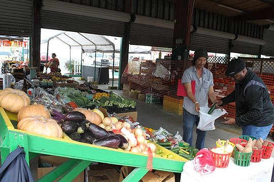 Sam So of Sam's Produce helps customer Vernon Norman bag vegetables during a quick shopping trip Monday afternoon to the Jacksonville Farmers Market, which is slated to start a $560,000 renovation.