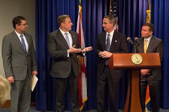 Ernst & Young executives Shawn Smith, second from left, and Mike Brennan, second from right, answer questions Thursday about logistics of the firm's expansion in Jacksonville. The company is creating 450 jobs as part of a deal that was lauded by local...