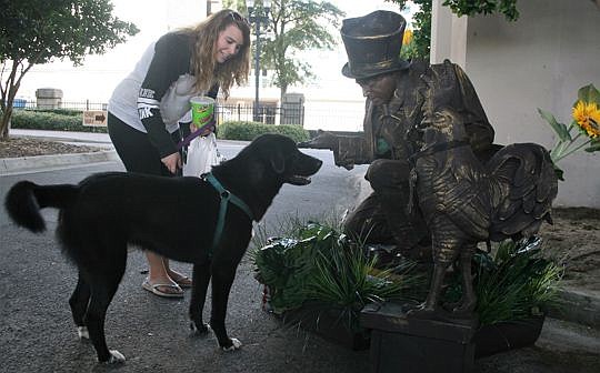 Bob Seymore of Palmetto, Ga., has been performing pantomime for more than 42 years. He specializes in living statue characters that capture the look of metal or stone. Among those enjoying his act Saturday at the Riverside Arts Market were Rachel Grue...