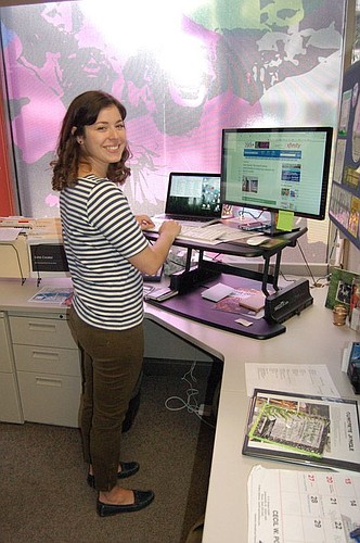 Katherine Hardwick, director of marketing, works standing up in her corner office along Adams and Laura streets.
