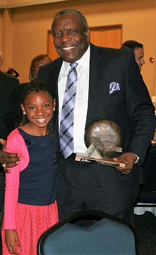 Edward Waters College President Nat Glover received the Junior Achievement of North Florida Thompson S. Baker Solid as a Rock Award on Tuesday. With Glover is Ariana Cobb, a JA participant.