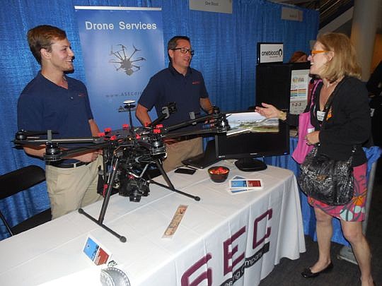 Aviation Systems Engineering Co.'s Ren Art, left, and Brent Klavon discuss the company's services with Sheila Gaspers, a WJCT corporate marketing representative, at the trade show.