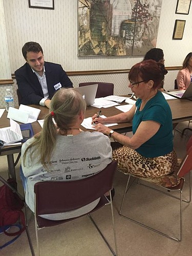Law Student, Nick Boyle and attorney, Lisa Dasher, assist senior citizens at Jacksonville Townhouse.