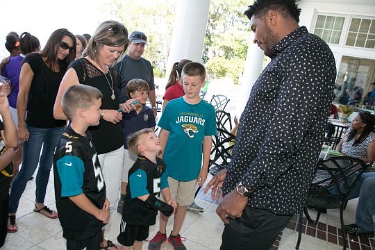 You sure are tall! A young boy looks way up at Jacksonville Jaguars tight end Julius Thomas on Monday at St. Vincent HealthCare's annual physician's golf tournament.