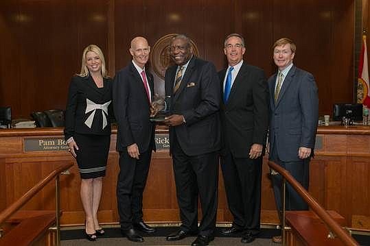 Gov. Rick Scott presented Edward Waters College President Nat Glover, both middle, with the "Great Floridian" award Tuesday. The recognition took place during the Cabinet meeting that featured, from left, Attorney General Pam Bondi, Scott, Glover, Chi...