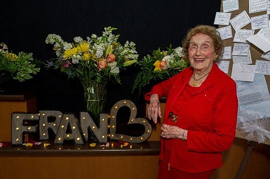Frances Bartlett Kinne, former Jacksonville University president and dean, poses in front of flowers and love notes given to her for her 99th birthday celebration Sunday at the school's Swisher Theatre.
