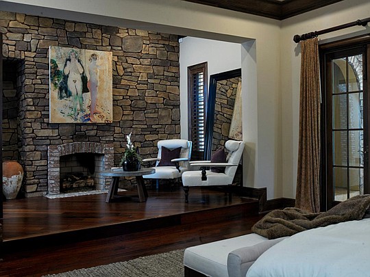 The master suite in Watson Realty Corp.'s Villa Serena includes a sitting area with a fireplace.