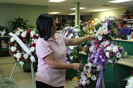 Kuhn Flowers is donating wreaths for a memorial wall and flowers for funeral services of the Orlando nightclub shooting victims in partnership with its sister store, Katherine's Florist in Clermont. Above is Michelle Morgan, vice president of Kuhn.