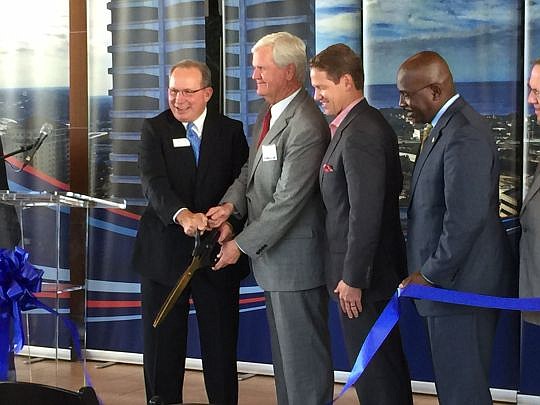 Ameris Bank President Andy Cheney, left, is joined by Ameris Bank Chairman Daniel B. Jeter, JAX Chamber President Daniel Davis and city Community Affairs Director Charles Moreland, among city and bank executives, to cut the ceremonial ribbon Tuesday t...