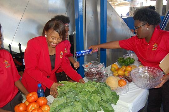 Betty Burney, founder and executive director of I'm A Star Foundation, helps get merchandise ready Wednesday at the unveiling of the Rosa Parks Produce Market. The foundation will sell fresh fruit and vegetables at the Rosa Parks Transit Station Downt...