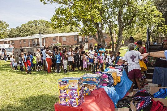 Children at Eureka Garden line up for backpacks for the new school year.