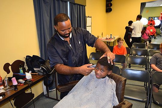 Steve Brightwell was one of four barbers who gave haircuts to children getting ready for school Aug. 13 at the Impact Church Arlington campus during the inaugural two-day Back-to-School Bash. The church adopted 13 public schools in the neighborhood an...