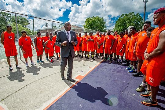 Edward Waters College President Nathaniel Glover chats with members of the school's football team as they practice on a hot August morning on old basketball courts. He makes the players promise they will make the best of their opportunity at the colle...