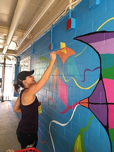 Christie Chandler of Arts Evolution painted a mural for Girl Matters at George Washington Carver Elementary School.