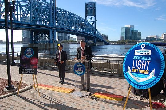 Gator Bowl Sports CEO Rick Catlett, at podium, was joined Tuesday by Community First Credit Union CEO John Hirabayashi to announce a change in schedule for the Community First Jacksonville Light Boat Parade.