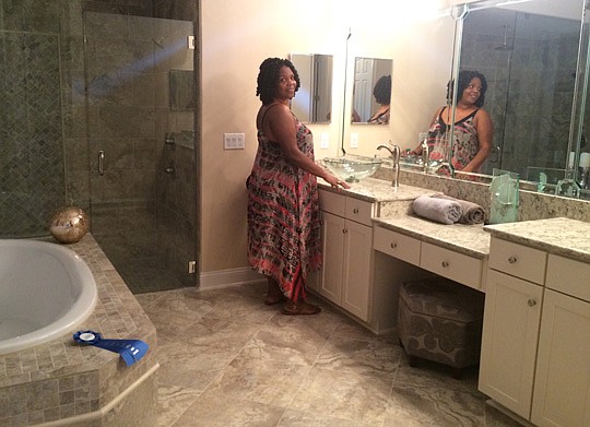 Amelia Dadybo glances over her shoulder while touring the large master bathroom in the Carrara II floorplan by D.S. Ware Homes. Dadybo and her husband have selected the floorplan for their home.