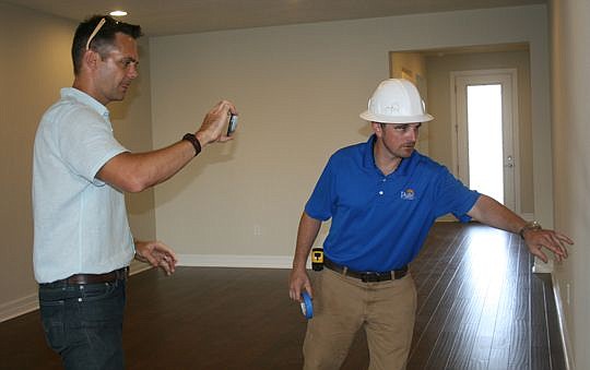 Self-described techie Josh Rogers, left, of Keller Williams Jacksonville Realty uses his cell phone to video a walk-through of a new home with Pulte Homes superintendent David Wolfe. Afterward, Rogers uploaded the video to YouTube so the homebuyers- a...